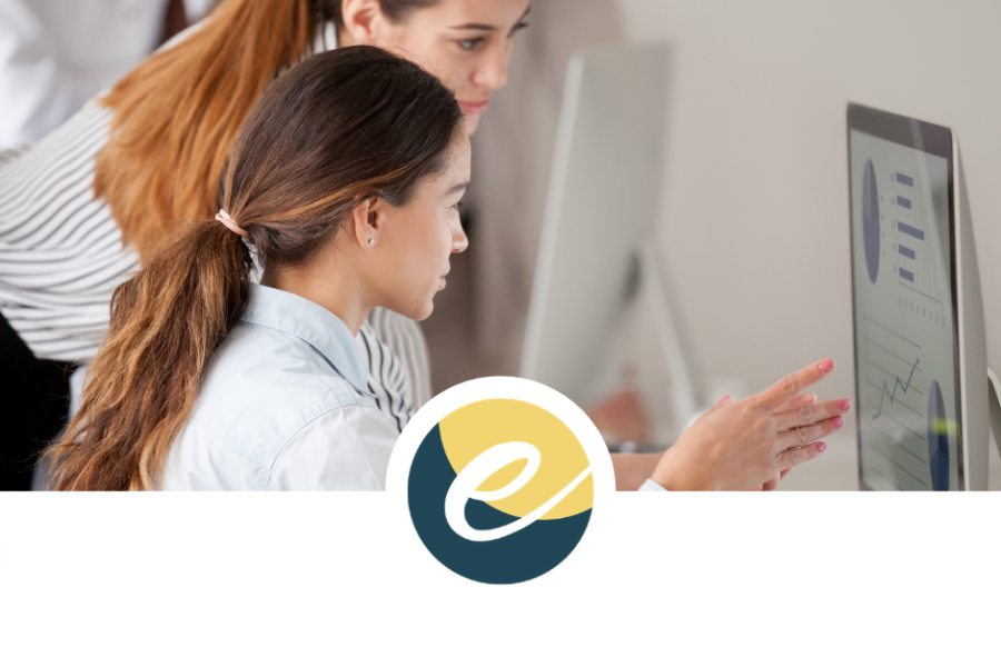 two women at a computer, one provides coaching to the other